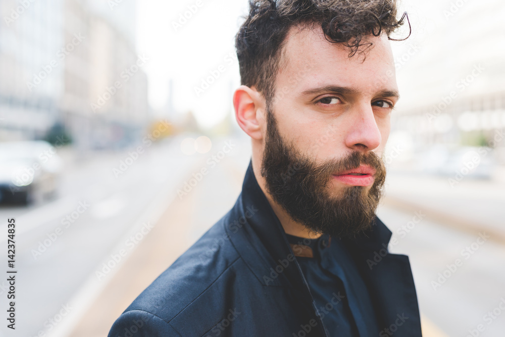 Obraz premium Portrait of young bearded caucasian man outdoor looking camera - customer, serious concept