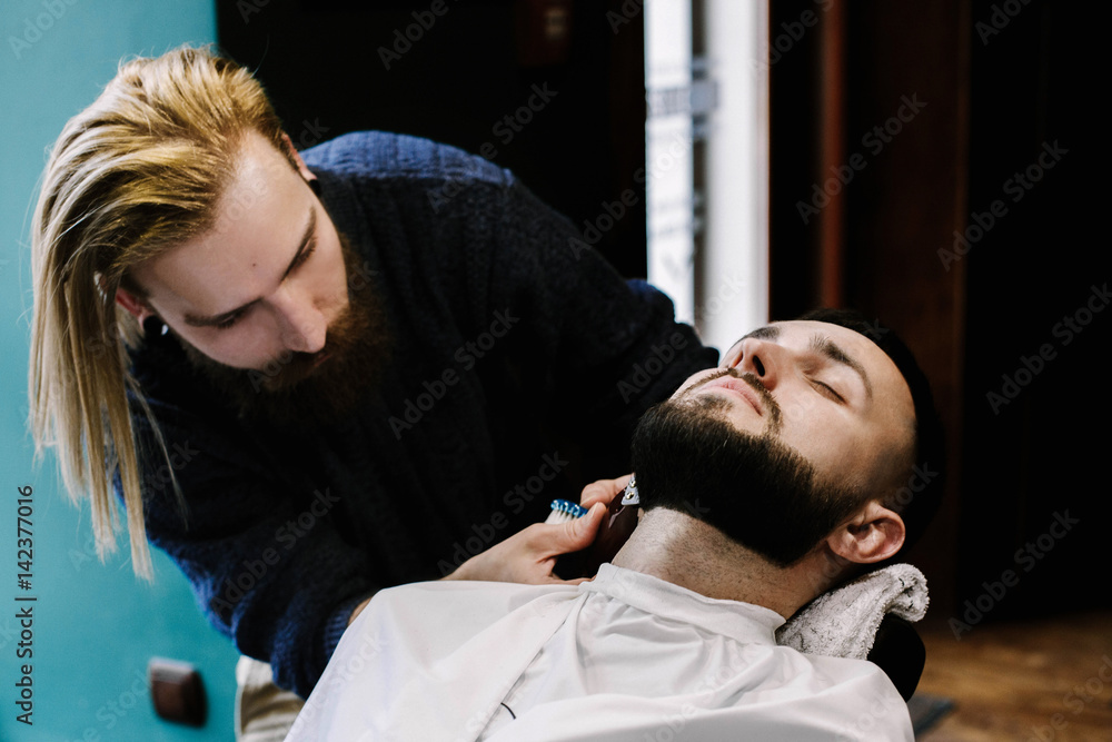 Fototapeta premium Barber cleans hair off man's neck