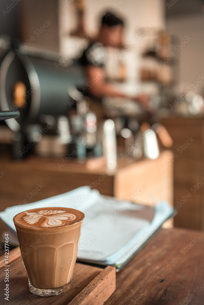 White cup of hot coffee on table in cafe. 