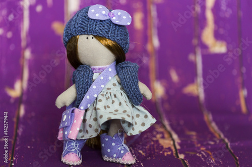 Текстильная кукла в голубой платье в горошек, в вязанных синих шапке и жилете, в кедах из фиолетового и розового фетра, с сумочкой из фетра 