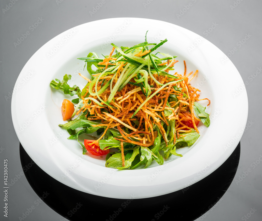 Vegetarian salad with fried potato chips and arugula on a plate Vegetarian salad with fried potato chips and arugula on a plate