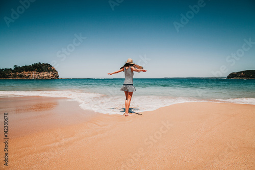 Woman dances in front of the beach in Australia.