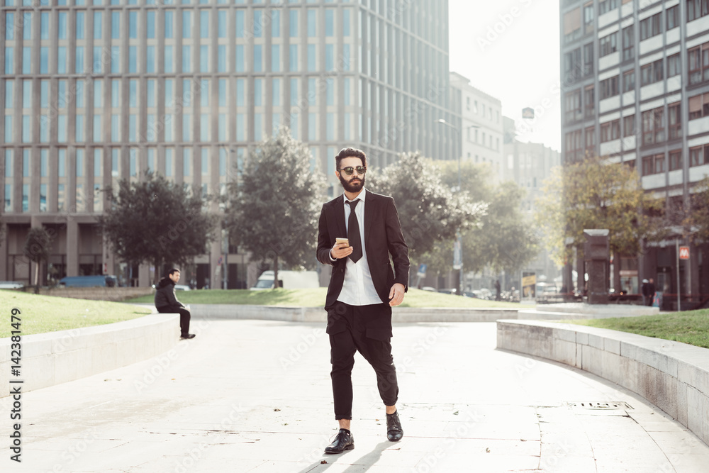 Young bearded man using smart phone outdoor in the city - technology, business, social network concept Young bearded man using smart phone outdoor in the city - technology, business, social network concept