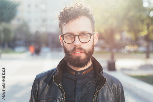 Portrait of young bearded caucasian man outdoor looking camera - customer  serious concept