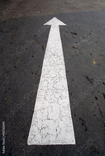 The arrow on the asphalt showing the direction of motion.