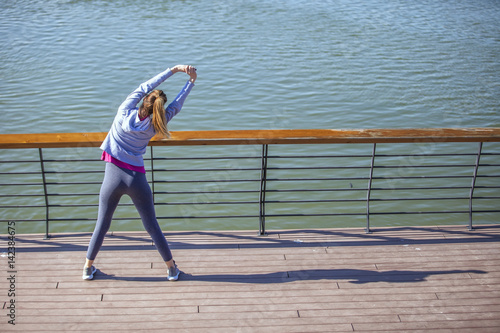 Morning exercise along the river. A young woman on recreation and jogging