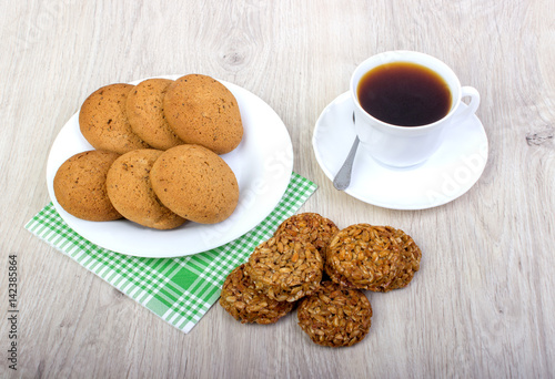 A cup of coffee and assorted cookies on the table.