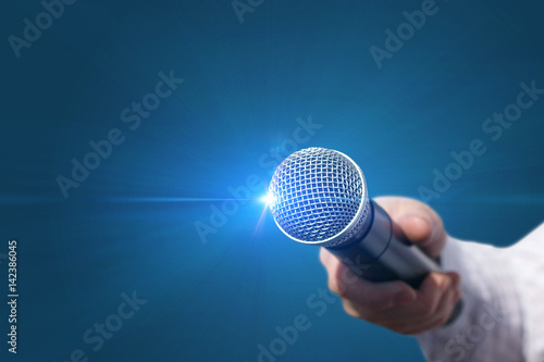 Female hand with microphone .