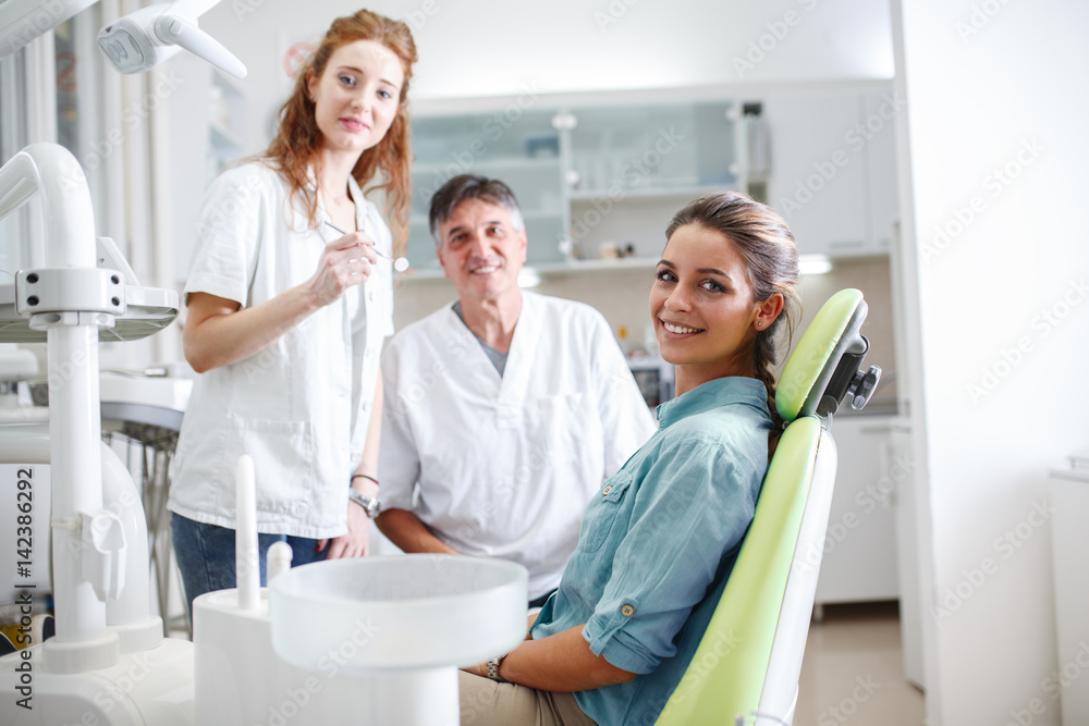 Young female patient sitting on dental chair and preparing for treatment. Young female patient sitting on dental chair and preparing for treatment.