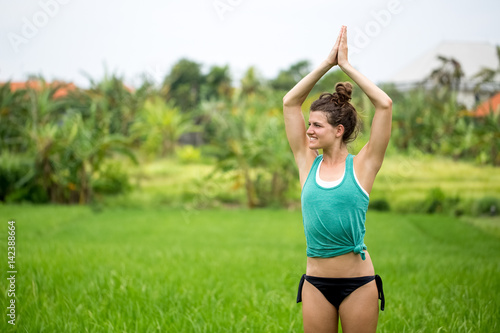 Smiling Young Woman Doing Yoga on Summer Meadow photo