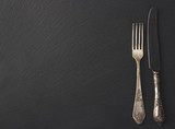 Melchior spoon and fork on the black stone background