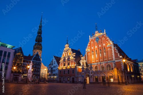 RIGA, LATVIA - 12 JUN 2016: City Hall Square with House of the Blackheads and Saint Peter church in Old Town at evening