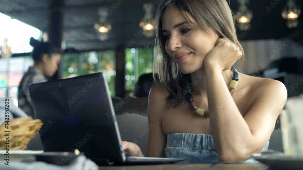 Young, pretty woman using laptop sitting in cafe
Young, pretty woman using laptop sitting in cafe