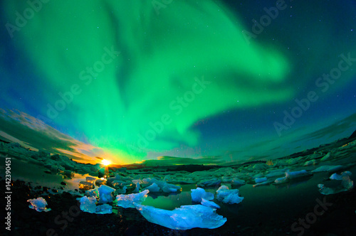 Dancing auroraborealis at night above glacier lagoon