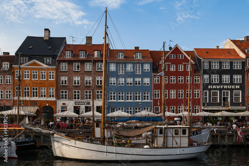 COPENHAGEN, DENMARK - 26 JUNE, 2016: People are relaxing in small canal with colorful houses and boats
