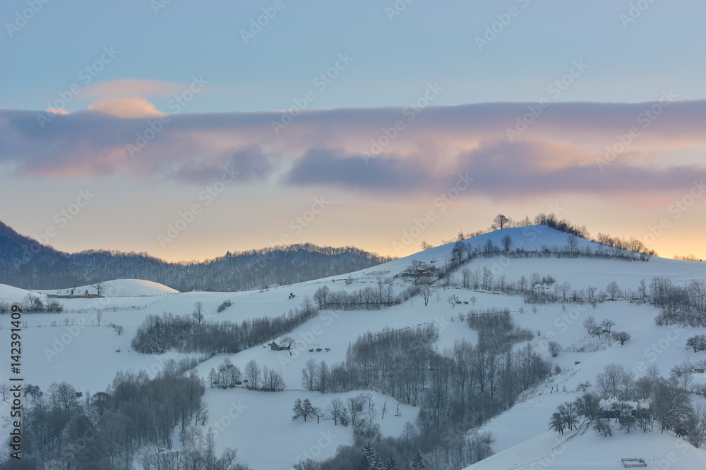 Beautiful winter mountain landscape with snowflakes in frosty winter day. Carpathian wild mountains. Romania. Holbav. Bran. Brasov. Romania. Little noise. Colorful winter sky.