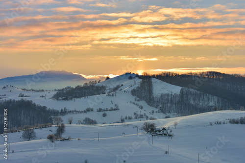 Beautiful winter mountain landscape with snowflakes in frosty winter day. Carpathian wild mountains. Romania. Holbav. Bran. Brasov. Romania. Little noise. Colorful winter sky.