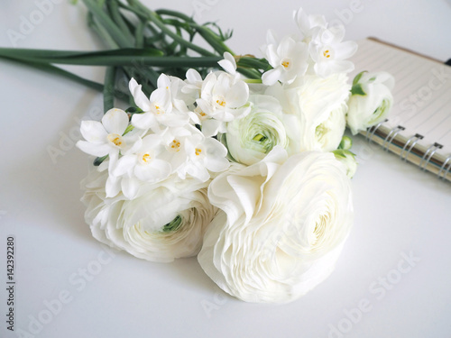 Fototapeta Naklejka Na Ścianę i Meble -  Spring styled stock photo. Still life with daffodils and Persian buttercup flowers, Narcissus, Ranunculus and notebook. Blurred background. Image for blog or social media.