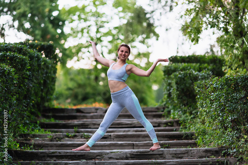 Pretty woman doing yoga exercises in the park