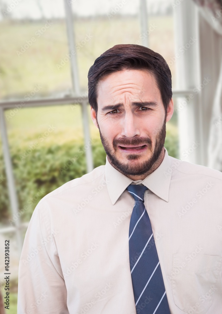Businessman worried crying against countryside window Businessman worried crying against countryside window