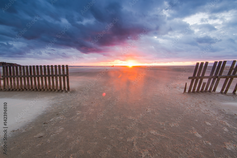 wind blowing sand on Tarifa beach in Spain at sunset