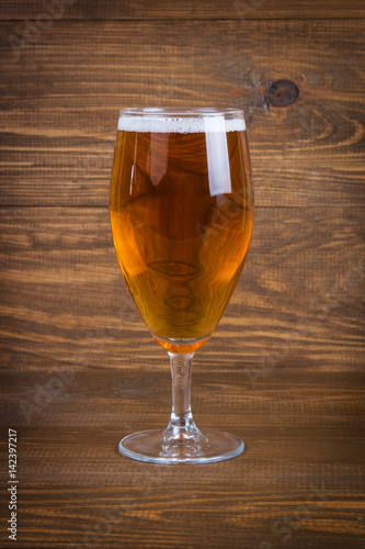 Lager beer in glass on wooden background