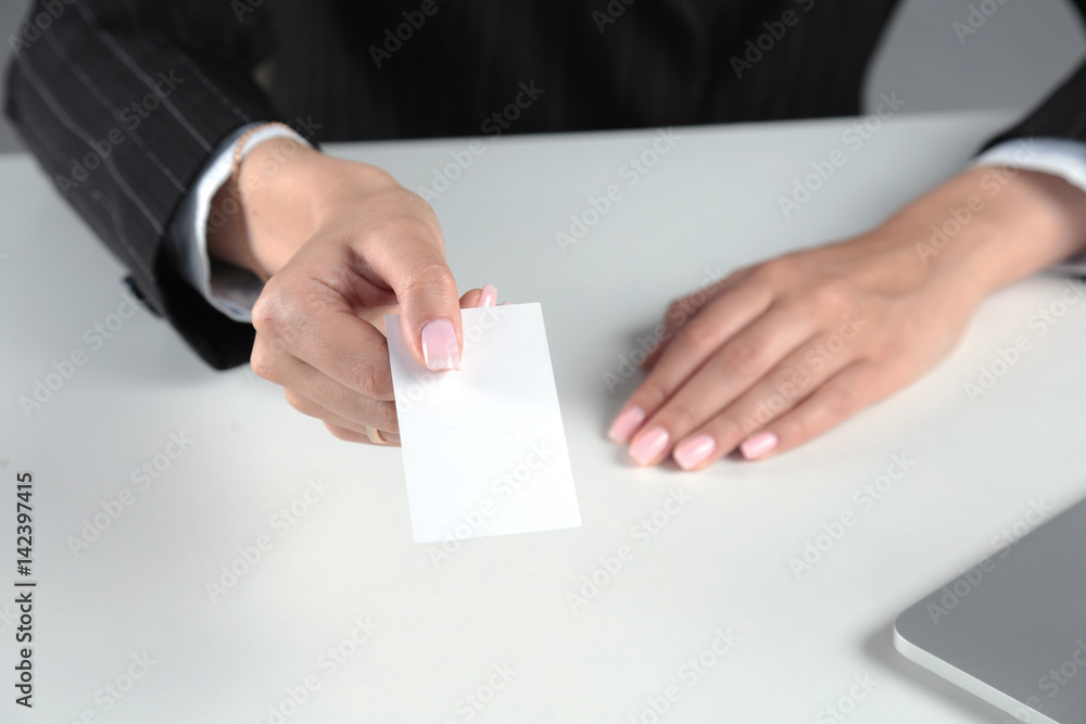Businesswoman holding blank visit card ,sitting on the desk Businesswoman holding blank visit card ,sitting on the desk