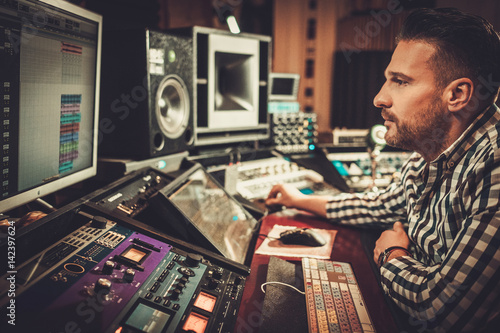 Sound engineer working in boutique recording studio. photo