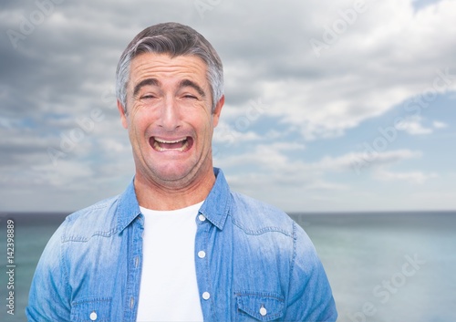 Man crying against sea