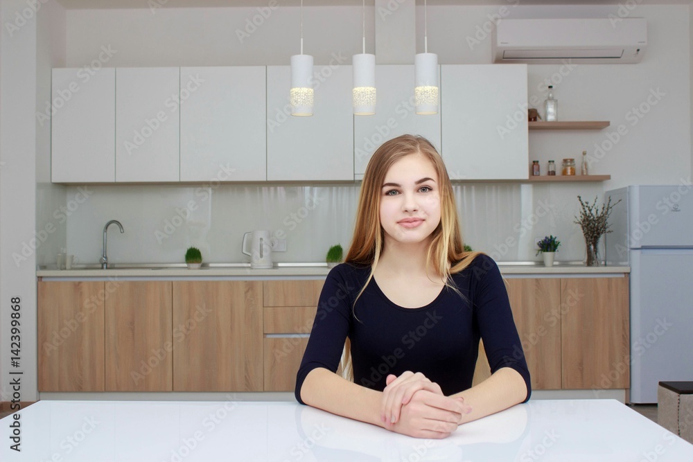 Young woman sitting a table in the kitchen