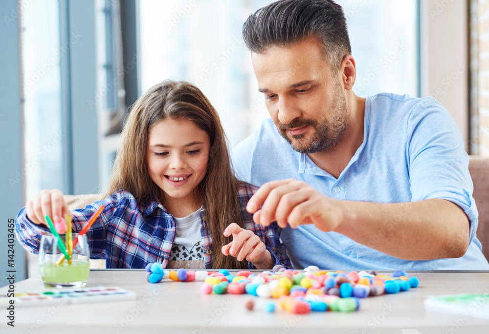 Beautiful little girl with her father playing with colored set for creativity Beautiful little girl with her father playing with colored set for creativity