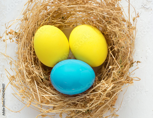 Happy Easter Card - space for text. Easter eggs in nest on rustic wooden background, selective focus image 