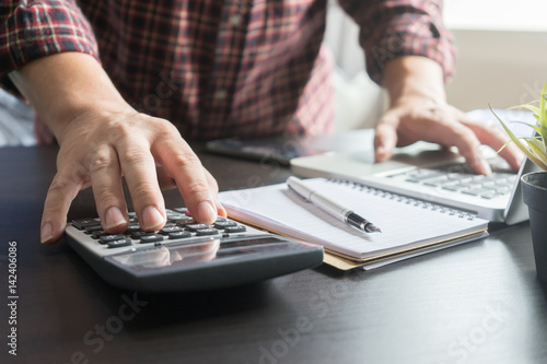 Businessman analyzing investment charts with calculator laptop. Accounting and technology in office.Business people using laptop at office,Analyze plans.selective focus,vintage color