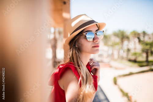 Portrait of sunny girl relaxing on summer sun wearind in hat and sunglasses. Summer vocation.