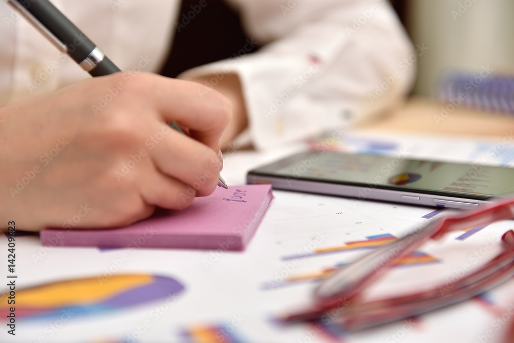 businesswoman writes data on sticker businesswoman writes data on sticker