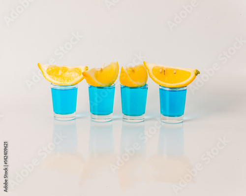Obraz na płótnie Four glasses of blue kamikaze, glamorous drink, mixed drink poured into shot gla
