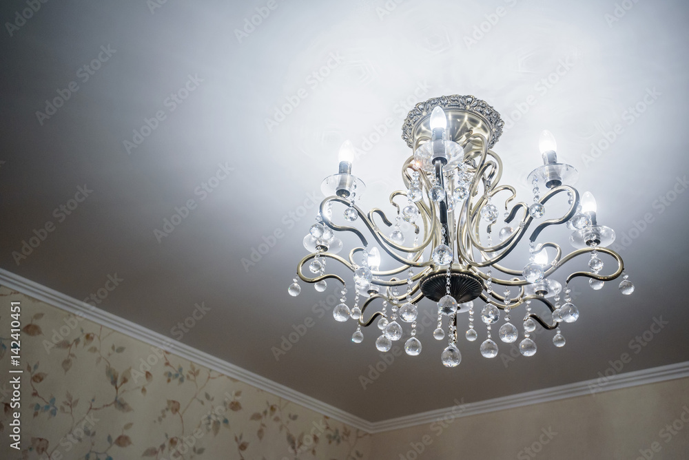 Modern crystal chandelier hangs from ceiling