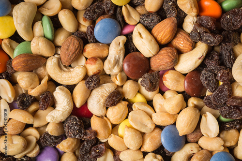 Close up of pile of trail mix with nuts, raisins, and candy