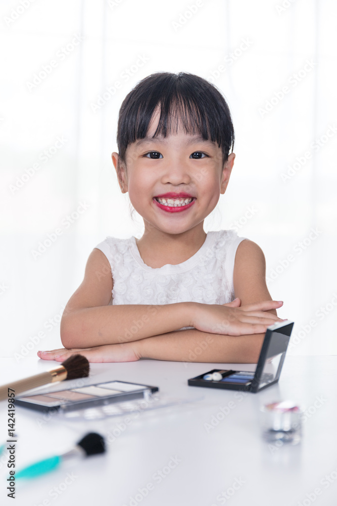 Asian Chinese little girl applying makeup with cosmetics Asian Chinese little girl applying makeup with cosmetics