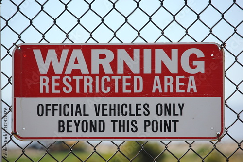 Restricted Area sign on metal fence