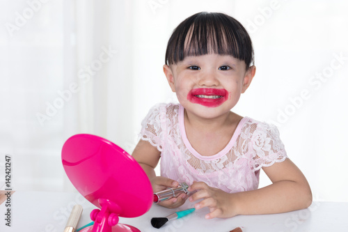 Asian Chinese little girl having fun with mess lipstick