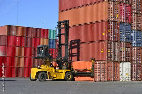 Toplifter handling cargo container loading to container trailer in import export logistic zone
