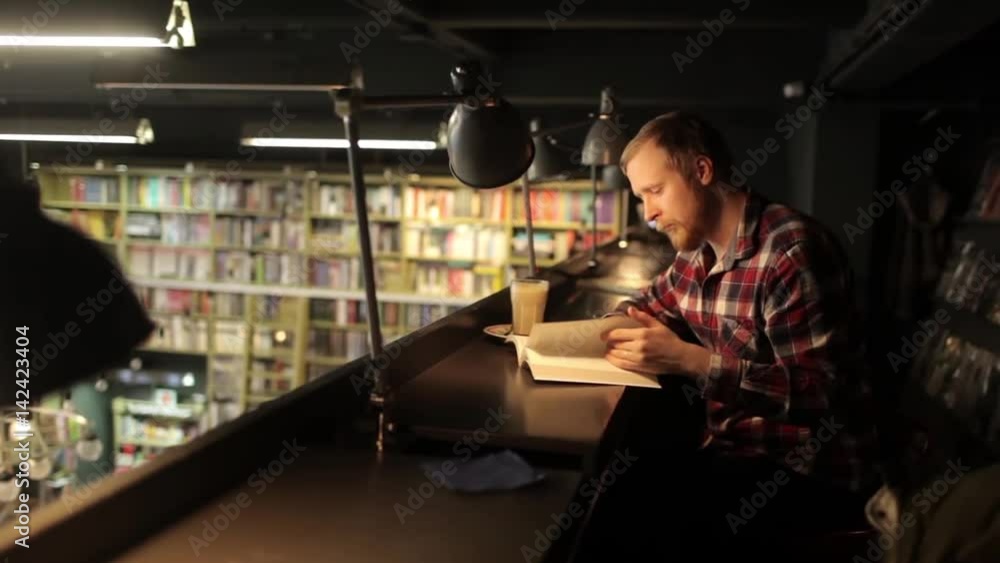 Man Reading a Book in a Bookstore, Library Man Reading a Book in a Bookstore, Library