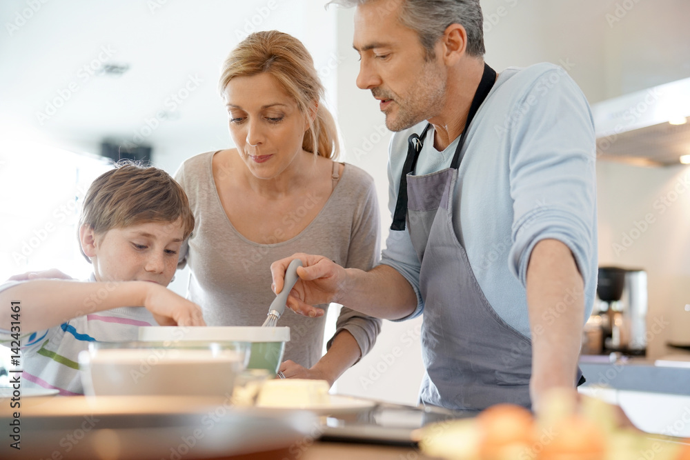 Family cooking together in modern home kitchen