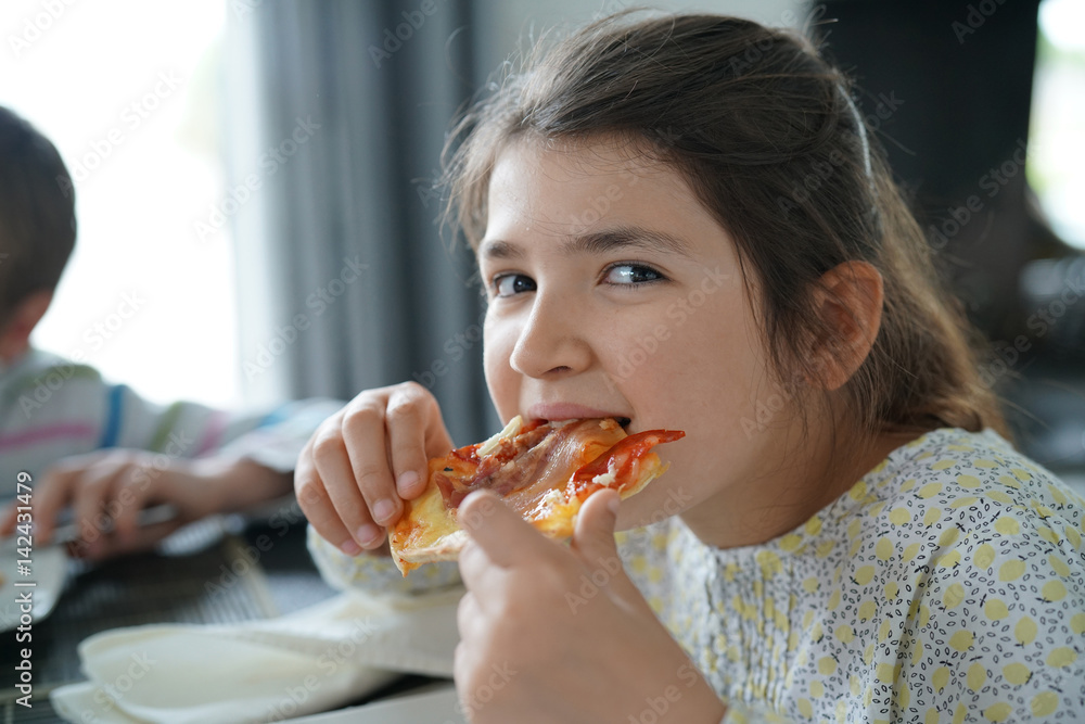 Portrait of kid eating slice of pizza
