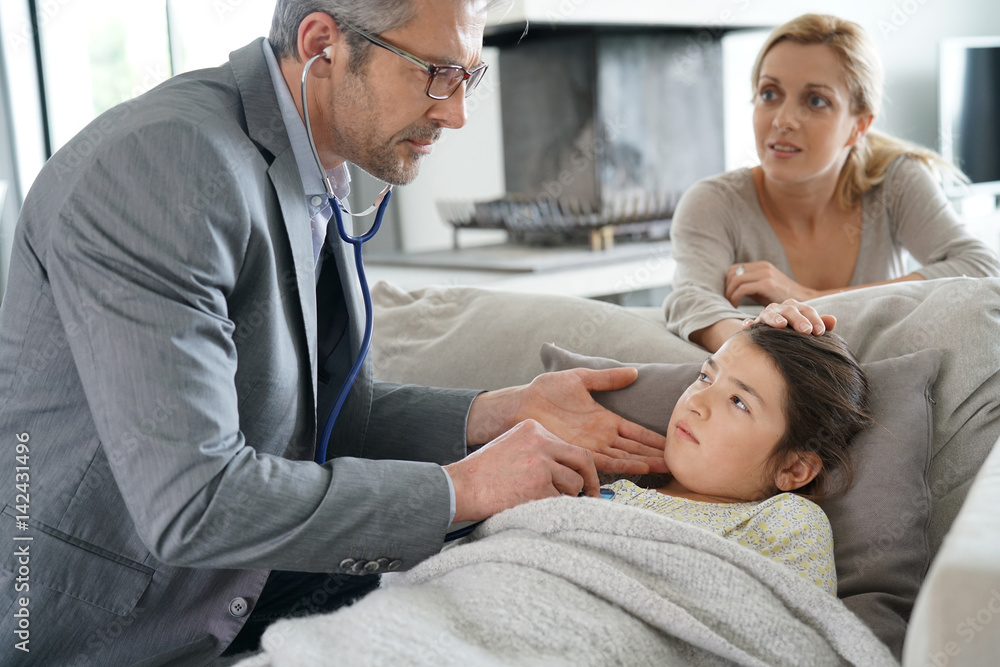 Obraz premium Doctor visiting sick little girl at her house