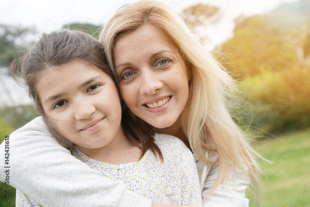 Portrait woman with daughter hugging outside Portrait woman with daughter hugging outside