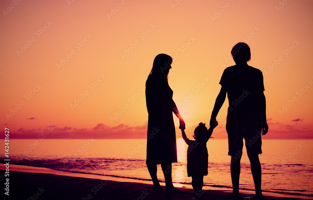 Happy family with child together at sunset