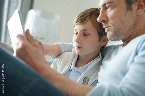Father and son websurfing on digital tablet