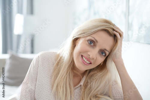 Portrait of beautiful blond woman standing at home